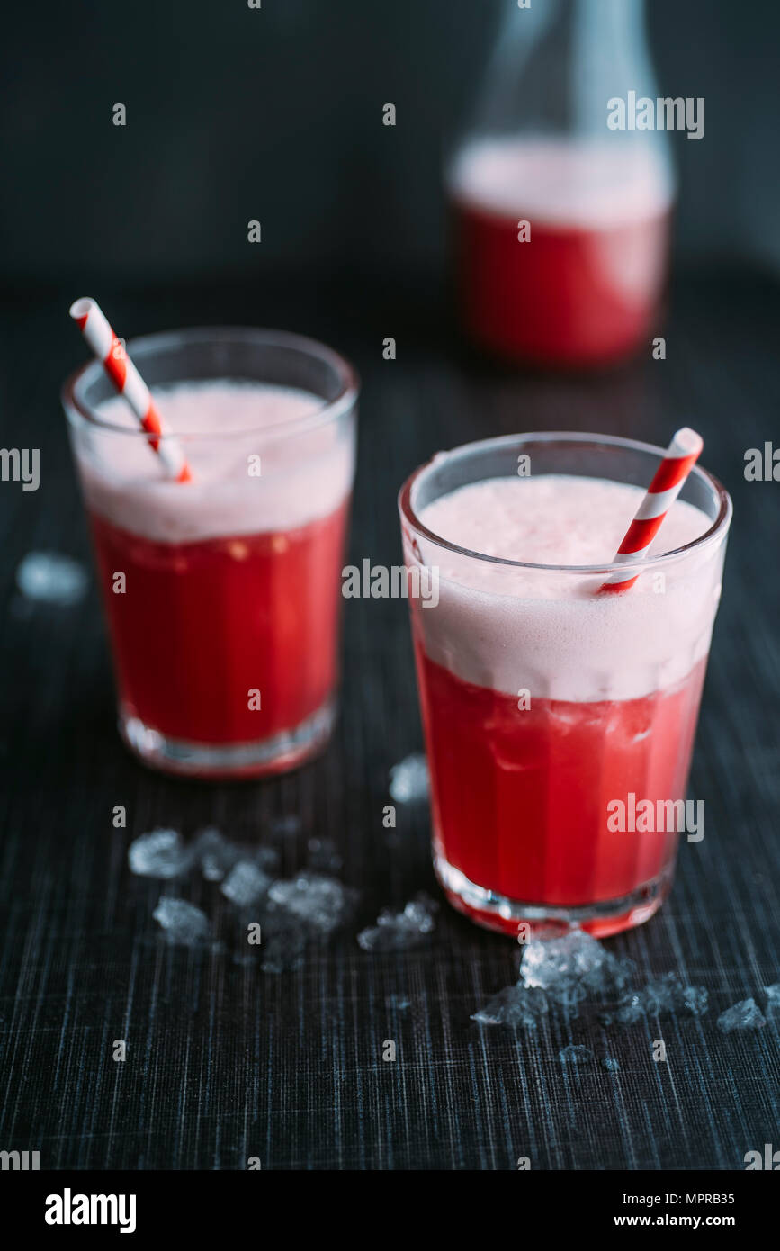 Verre : verre, Switchel avec gingembre, vinaigre de pomme, eau de noix de coco, jus de canneberges, citron, miel, glace cruched Banque D'Images