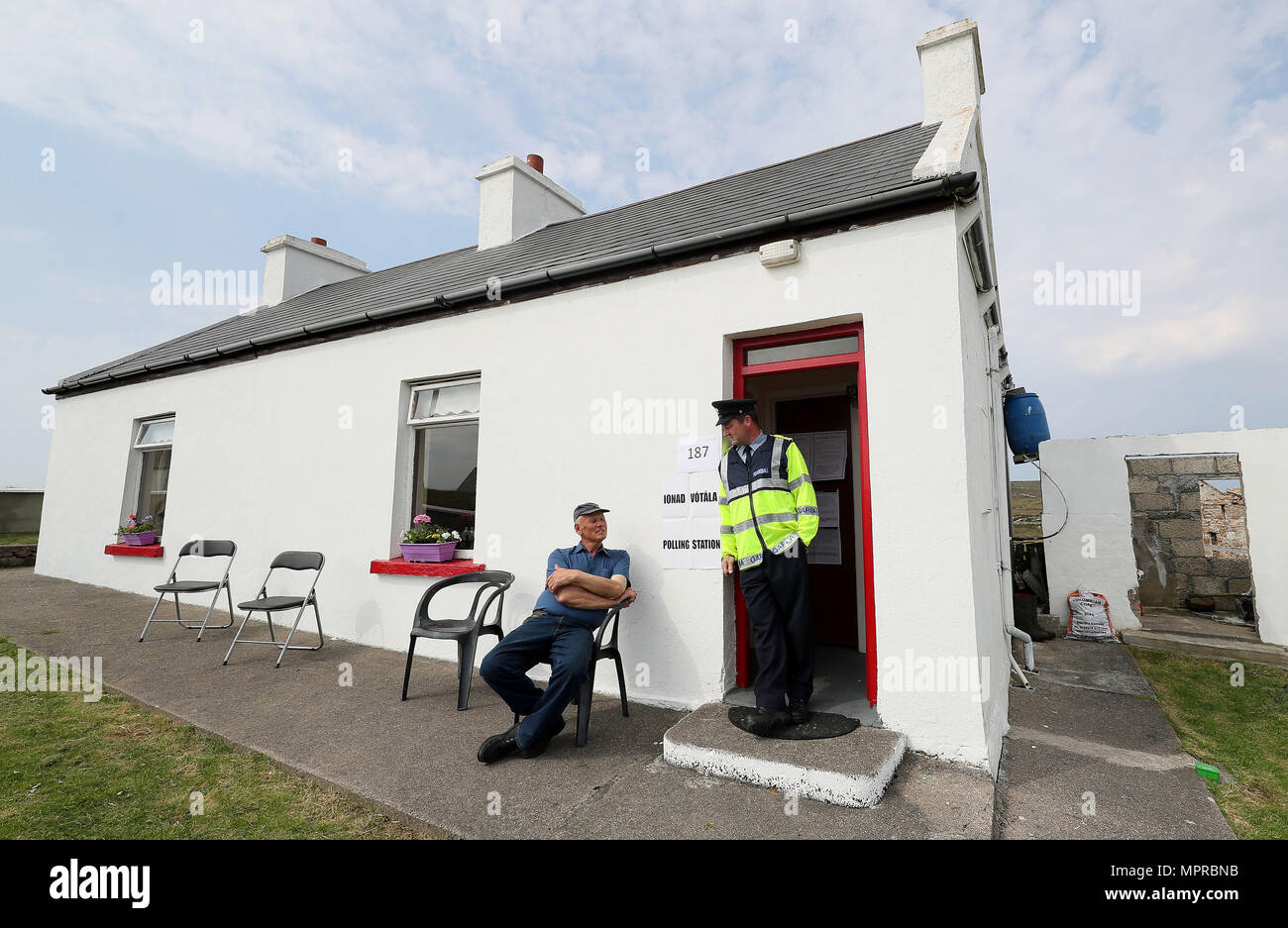 Résident de l'île de Gola, une île au large de la côte de Donegal, Irlande, Jimmy Sweeney (à gauche) parle avec Garda Pat McElroy comme il attend pour voter dans sa maison qui a été transformé en un bureau de scrutin pour la journée, que les Insulaires vont voter un jour d'avance sur le reste du pays d'exprimer leur vote au référendum sur le 8e amendement de la Constitution irlandaise. Banque D'Images