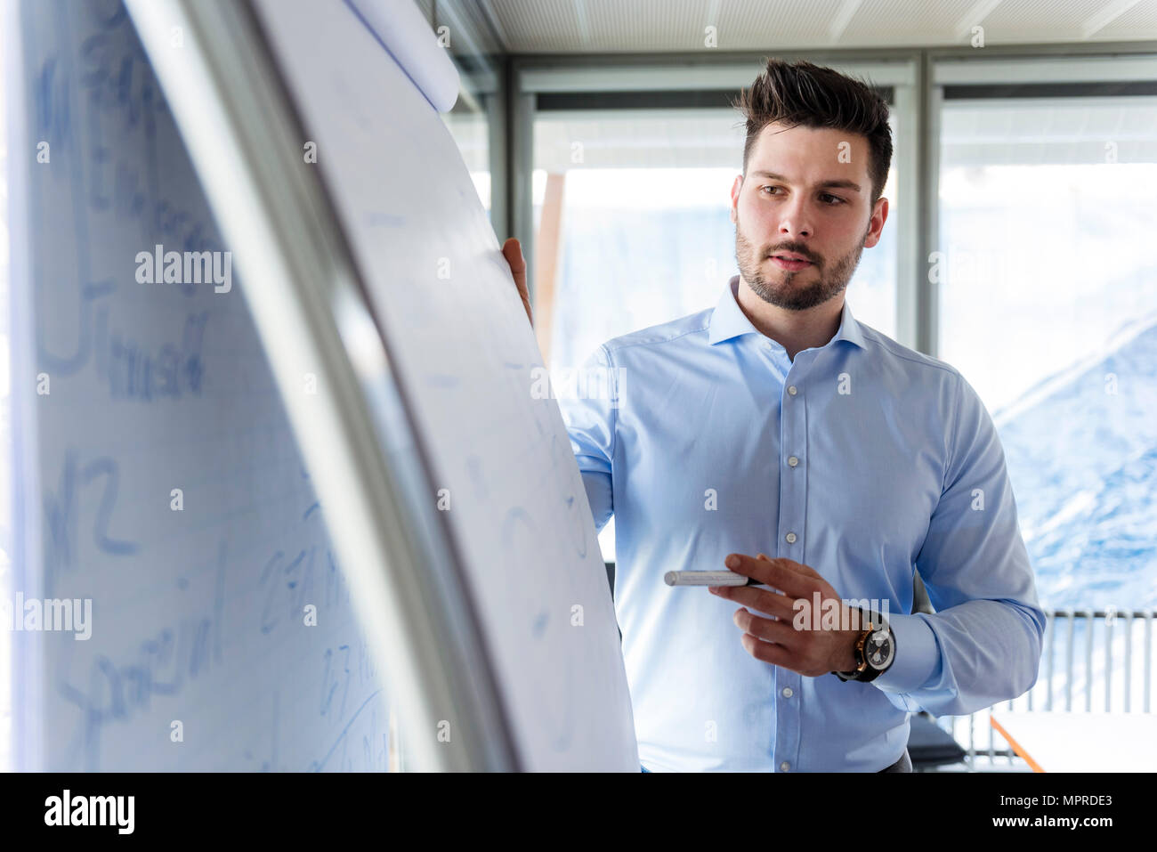 Businessmen standing at flipchart in office Banque D'Images