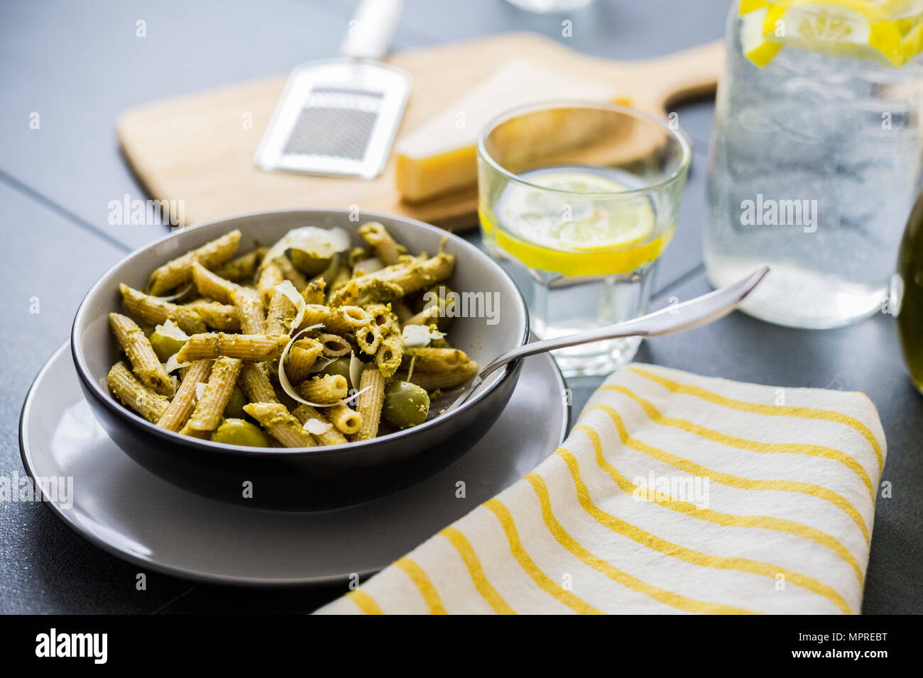 Les nouilles de blé entier avec du pesto vert et olives Banque D'Images