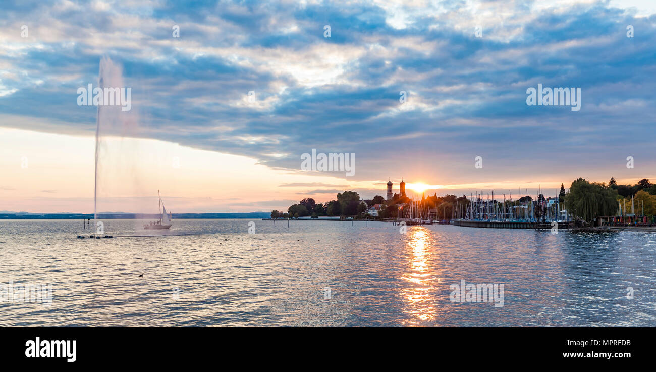 Allemagne, Bade-Wurtemberg, Friedrichshafen, le lac de Constance, vue sur la ville, la marina, fontaine au coucher du soleil Banque D'Images