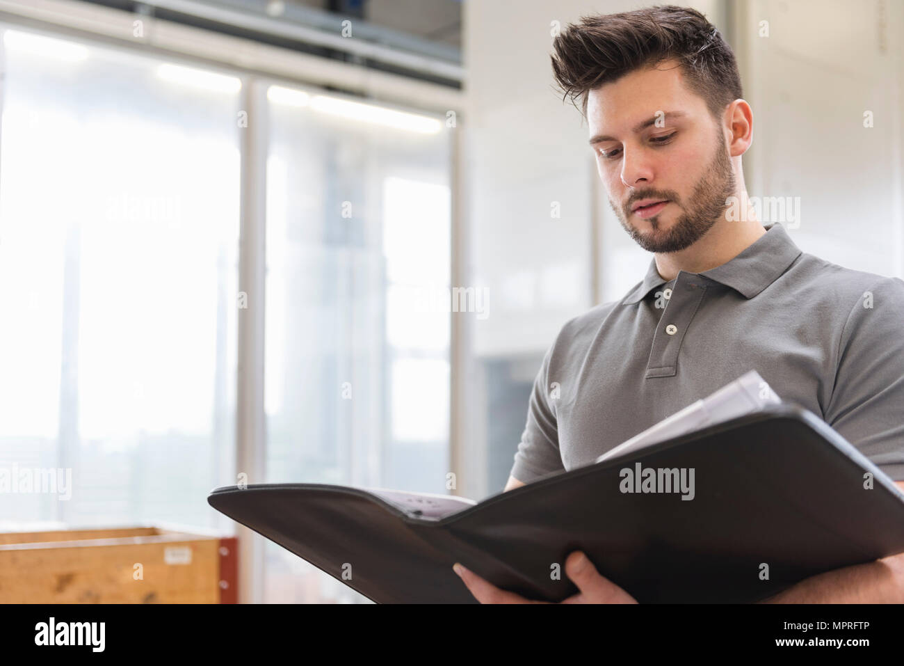 L'homme à la recherche de dossier dans l'usine Banque D'Images