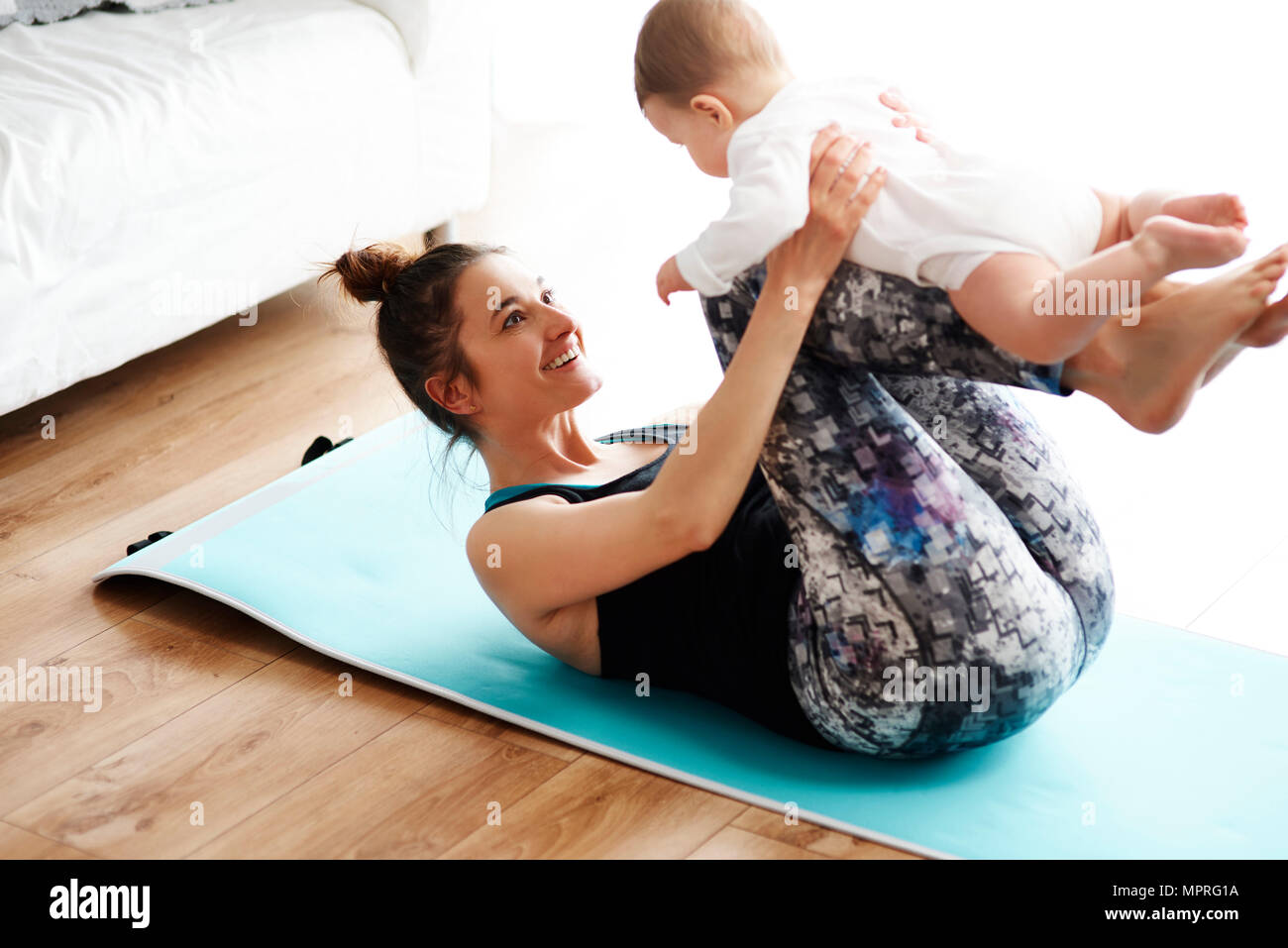 La mère et l'enfant l'exercice sur un tapis de yoga à la maison Banque D'Images