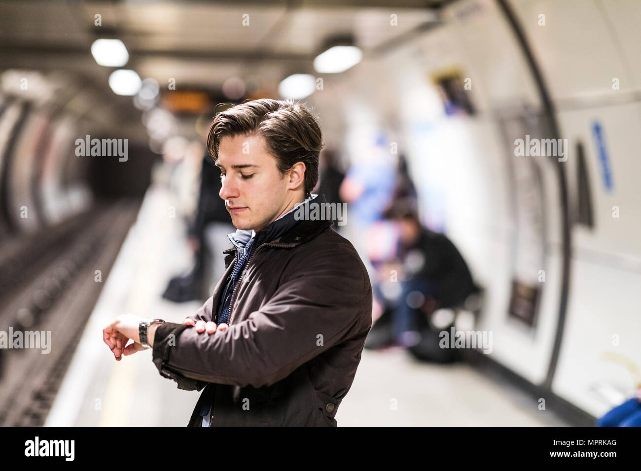 UK, Londres, homme d'affaires en attente à la station de métro contrôle du temps Banque D'Images