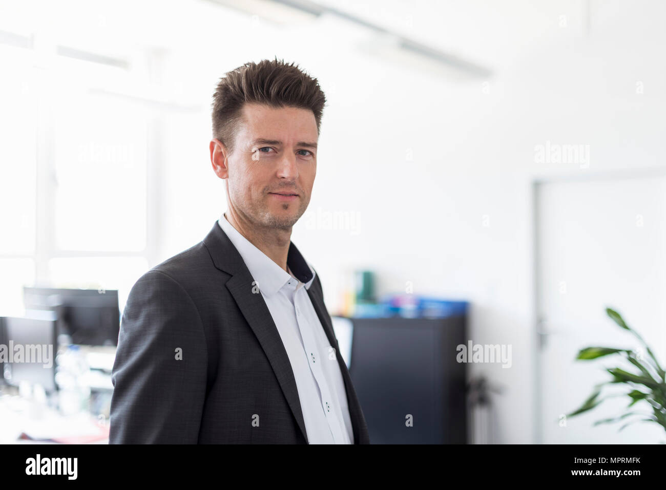 Portrait d'un homme d'affaires prospère standing in office, à de graves Banque D'Images