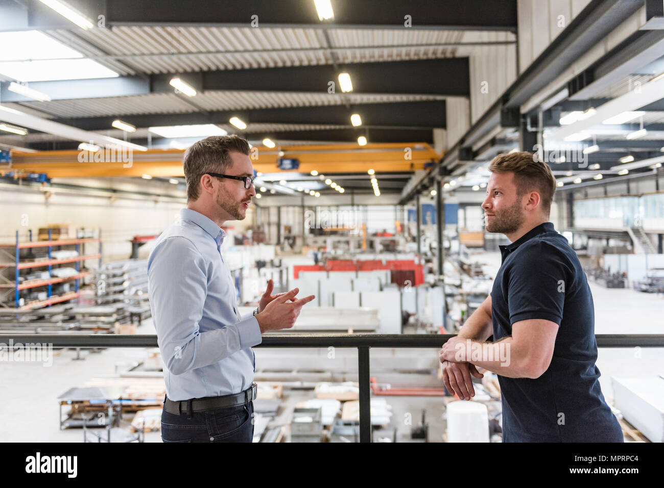 Deux hommes parlant le magasin d'usine marbre Banque D'Images