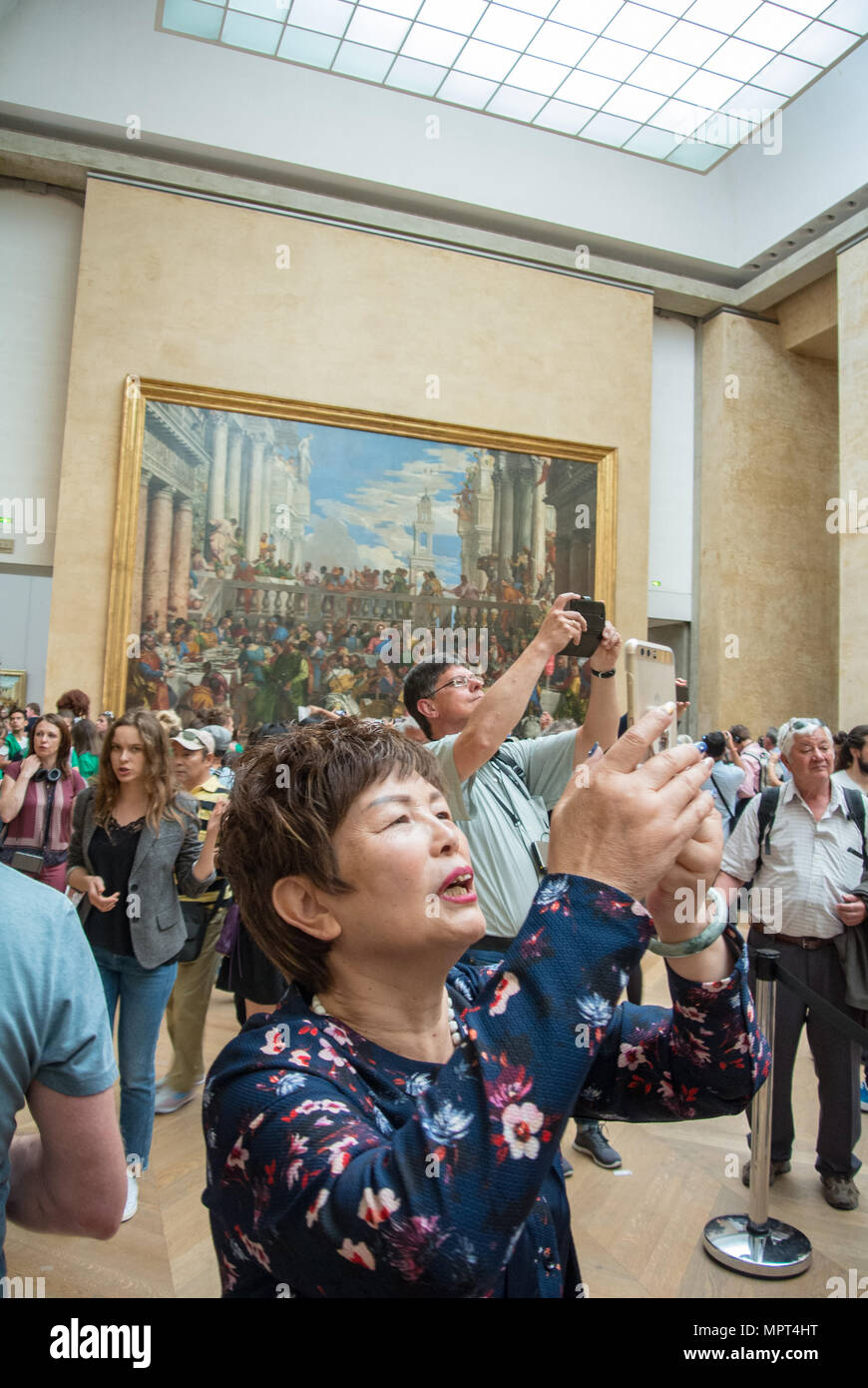 Un touriste chinois en photographiant l'art au musée du Louvre, Paris, France Banque D'Images