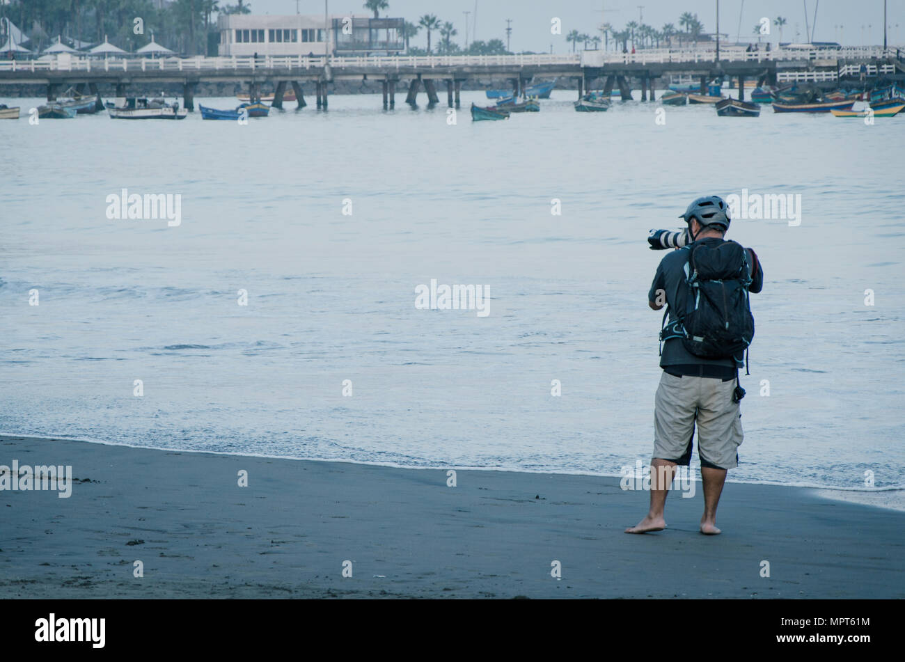 Le jeune photographe avec son appareil photo professionnel prise de photos de bateaux dans la mer, l'arrière-plan pour des vacances marines et de vacances travel concept Banque D'Images