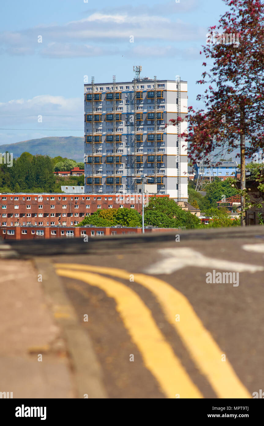 La haute tour d'habitation à la périphérie de Glagow Centre-ville, avec une double ligne jaune marquage de rue au premier plan. Banque D'Images