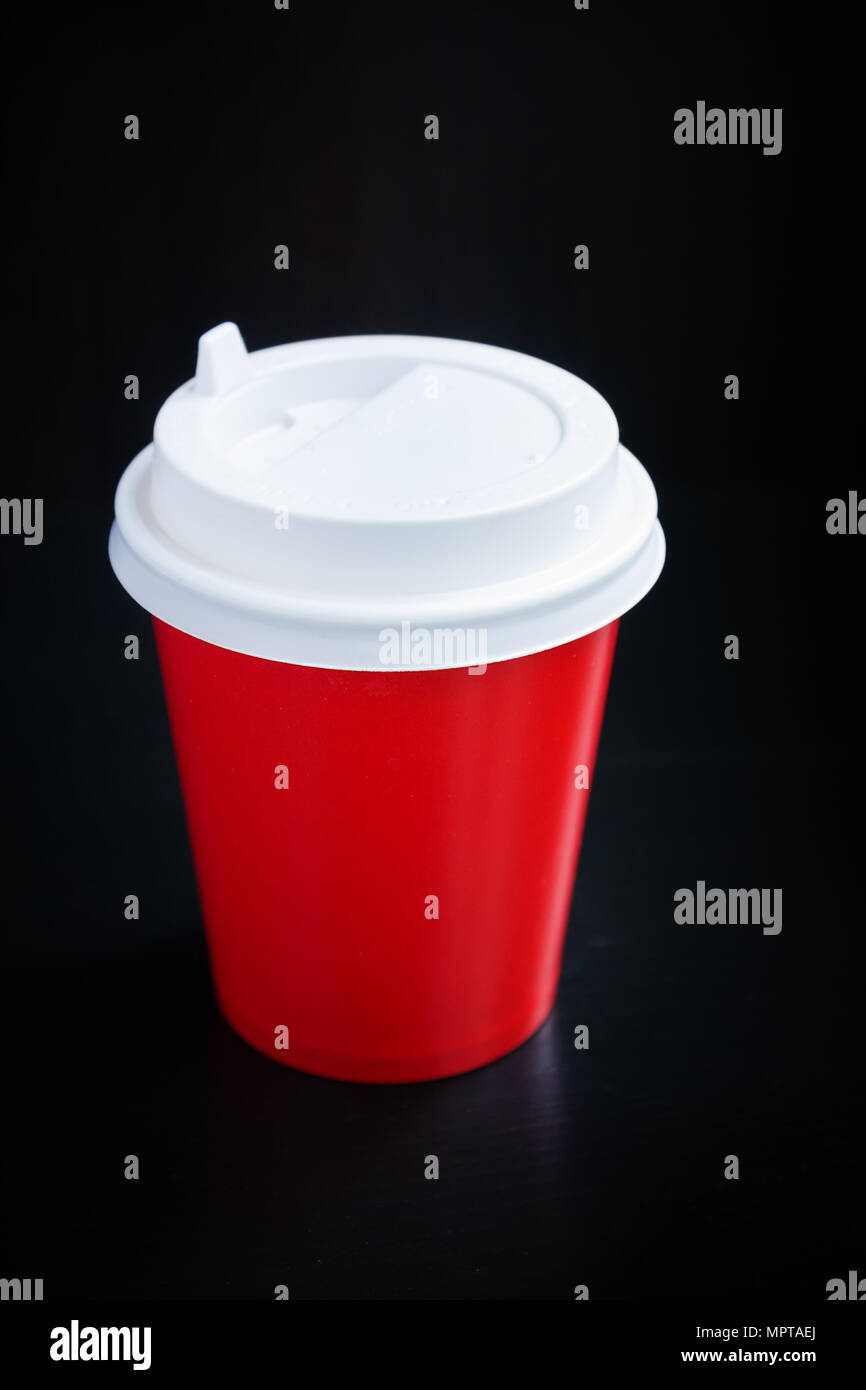 Tasse de café rouge sur fond noir. Café à emporter Banque D'Images