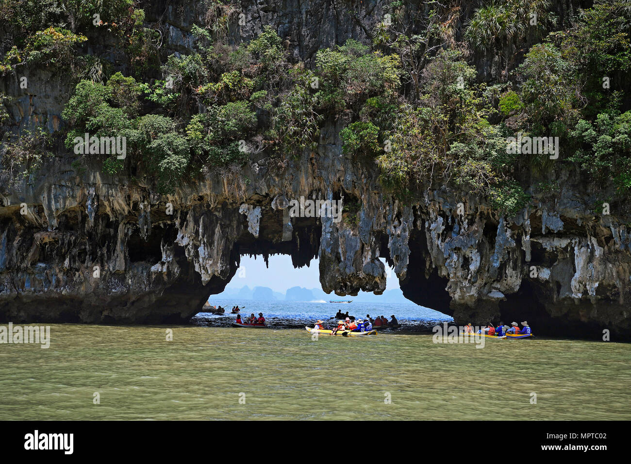 Les touristes explorant les roches calcaires érodés avec des canoës dans la baie de Phang Nga, Ao Phang Nga Marine National Park, Thaïlande Banque D'Images