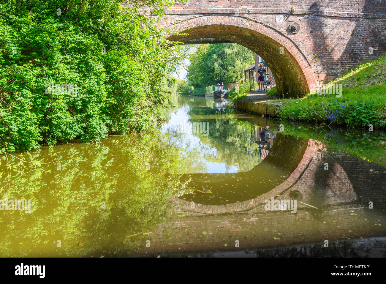 Pont de briques dans la lumière du soleil sur une journée de printemps ensoleillée à Market Harborough le bras du Grand Union canal, en Angleterre. Banque D'Images
