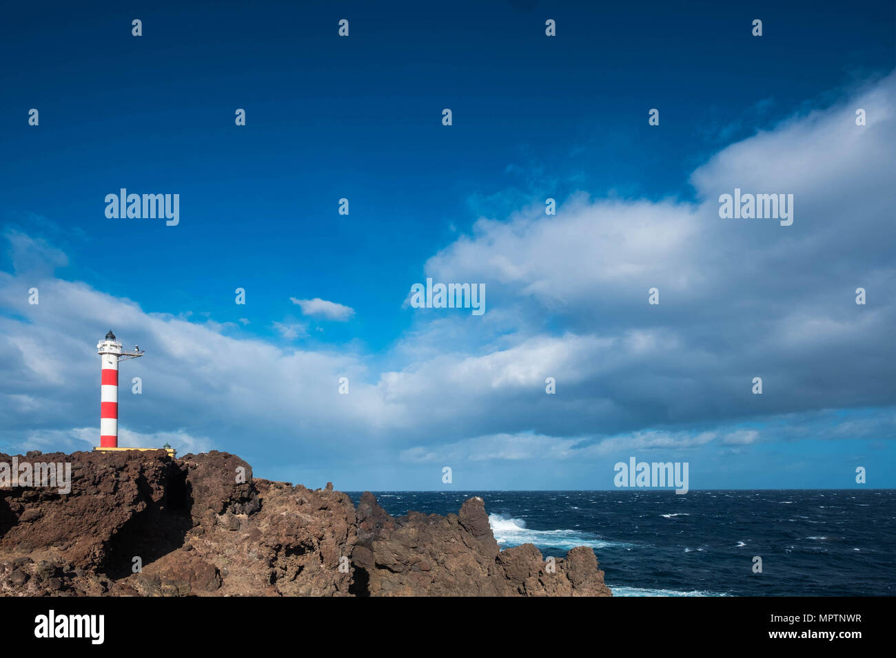 Vieux phare de Bonaventure en style classique, sur la côte de Ténérife, au milieu de l'océan atlantique. Puissance de la vague et isolées à la maison. Beau ciel bleu. Fre Banque D'Images