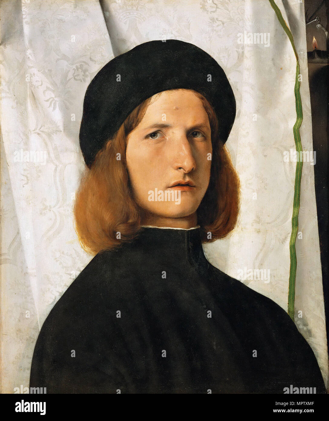 Portrait d'un jeune homme contre un rideau blanc. Banque D'Images