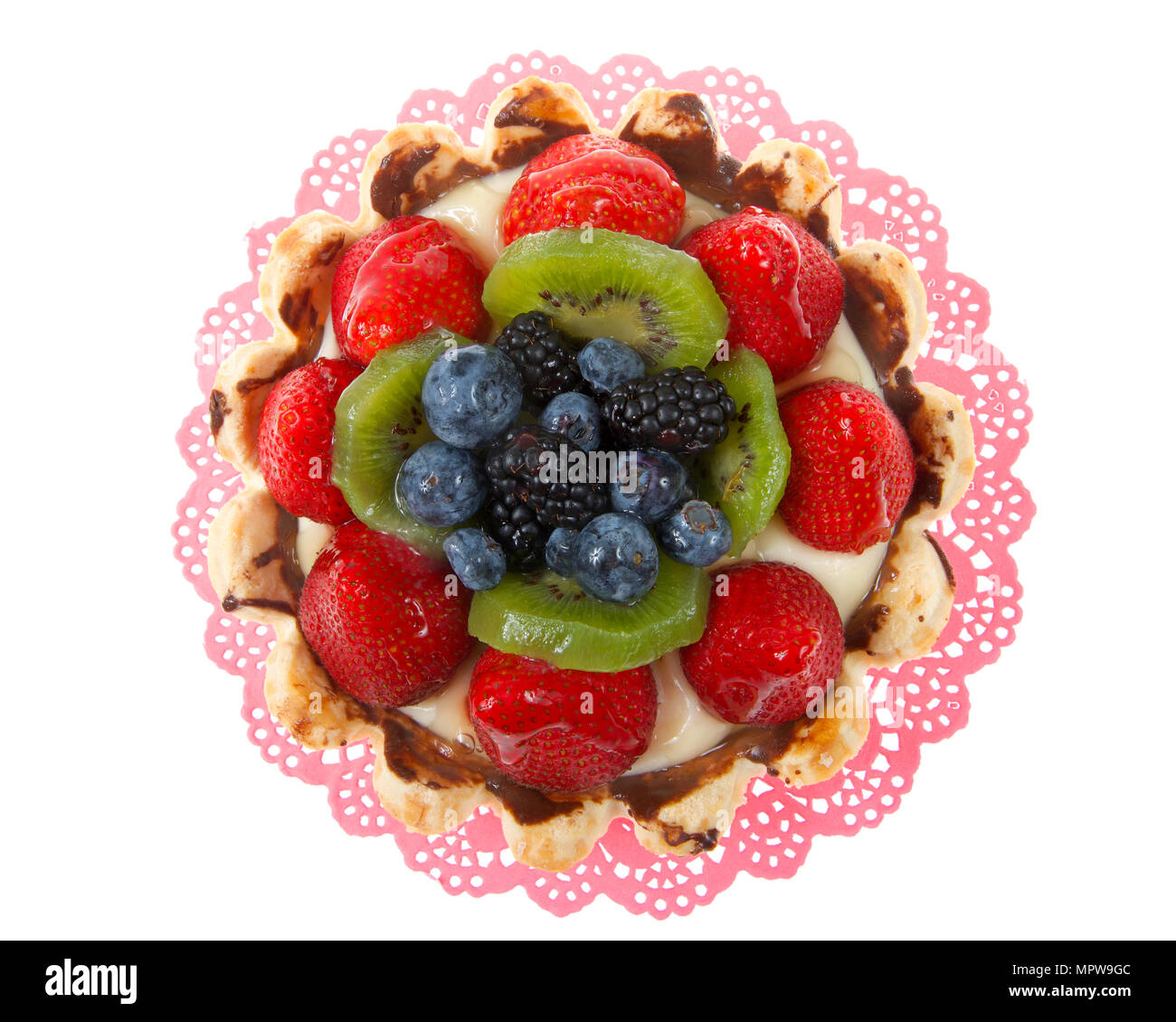 Tarte aux fruits d'été frais avec des fraises, kiwis, myrtilles, boysenberries sur un napperon rose isolé sur fond blanc Banque D'Images