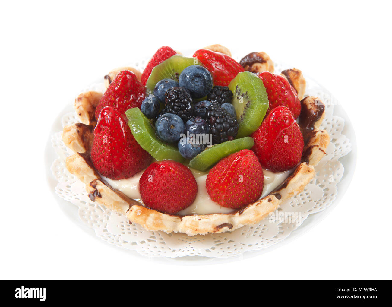 Tarte aux fruits d'été frais avec des fraises, kiwis, myrtilles, boysenberries sur un napperon blanc sur plaque isolé sur fond blanc. Banque D'Images