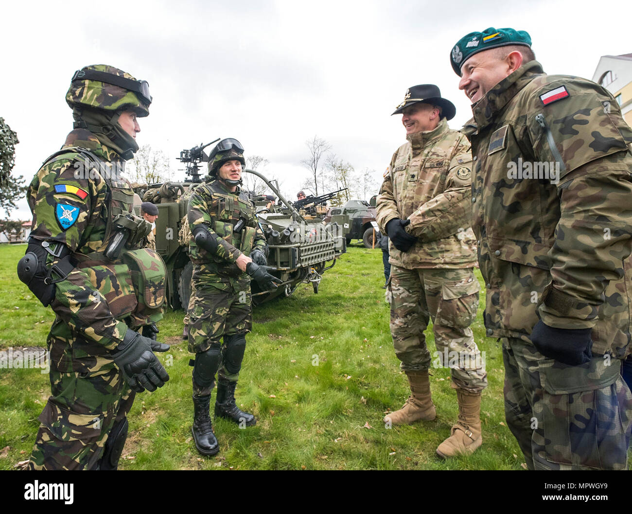 Des soldats des Forces terrestres roumaines s’entretiennent avec des officiers supérieurs de la 15e Brigade mécanisée polonaise et le commandant du groupement tactique de l’OTAN Pologne lors d’une journée portes ouvertes le 22 avril dans une académie militaire à Ełk, en Pologne. Le tirage photographique historique documente les activités de présence avancée renforcées impliquant l'armée américaine en Europe, le 2e régiment de cavalerie et les forces multinationales soutenant la dissuasion dans le nord-est de la Pologne. Banque D'Images