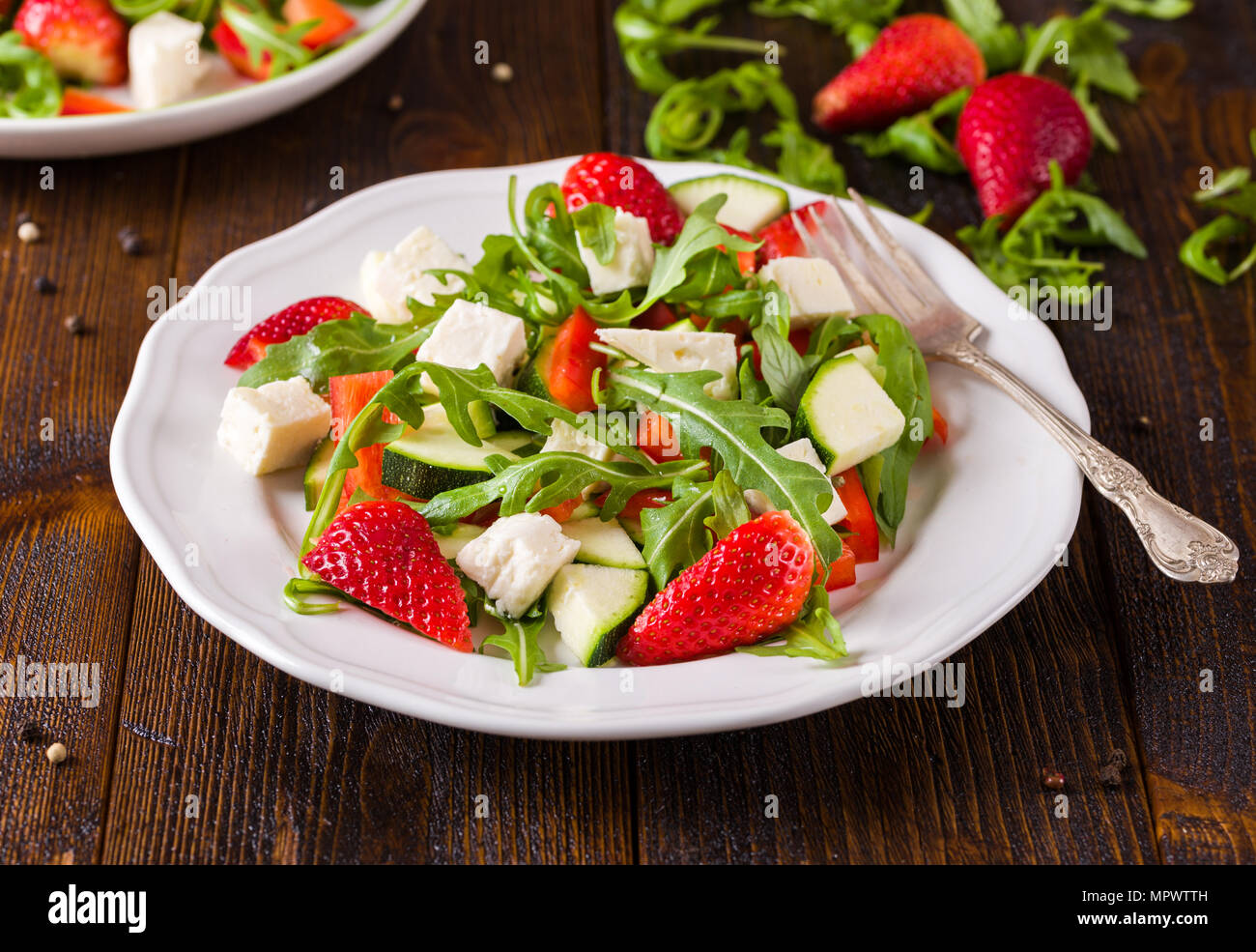 Salade de fraises et de légumes frais sur plaque blanche sur le bureau rustique naturel. Banque D'Images