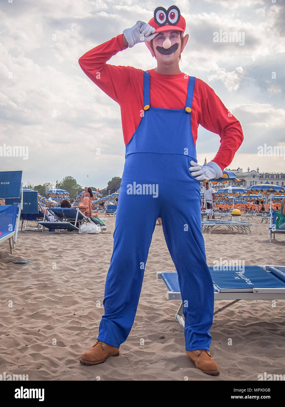 RIMINI, ITALIE - 22 juillet 2017 : Jeune homme cosplayeur dans le costume Mario posant sur la plage Banque D'Images