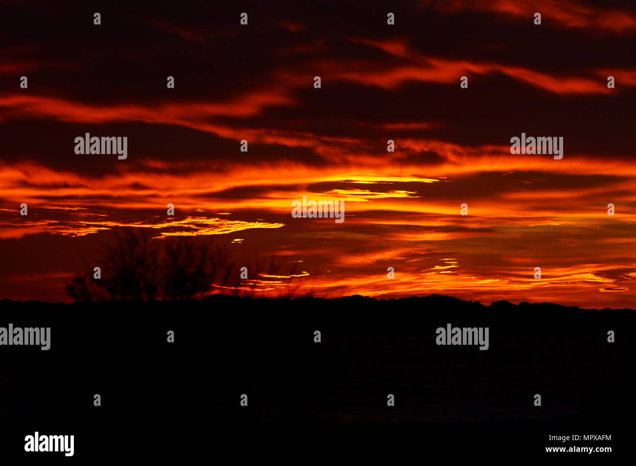 Nuages rouges au coucher du soleil comme un ciel brûlant d'un coucher de soleil spectaculaire de la Savina (Formentera, îles Pityusic, îles Baléares, Espagne) Banque D'Images