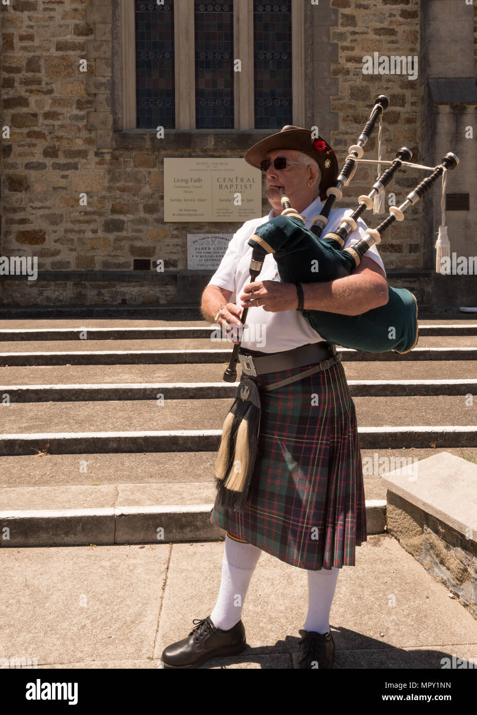 Un joueur de cornemuse jouant un air à l'extérieur d'une église à Albany, Australie Banque D'Images