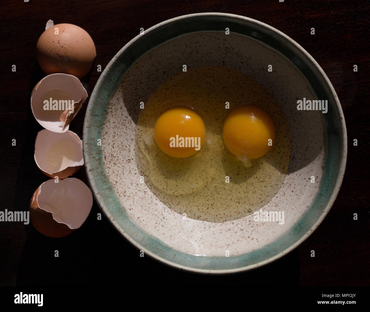 Vue aérienne d'oeufs cassés dans un bol par des obus sur la table Banque D'Images