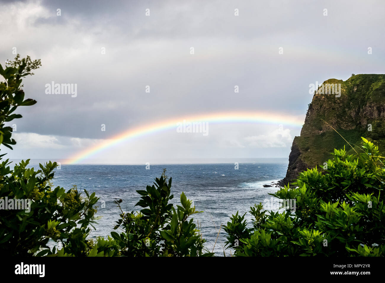 Vue panoramique de l'arc-en-ciel sur mer contre ciel nuageux Banque D'Images