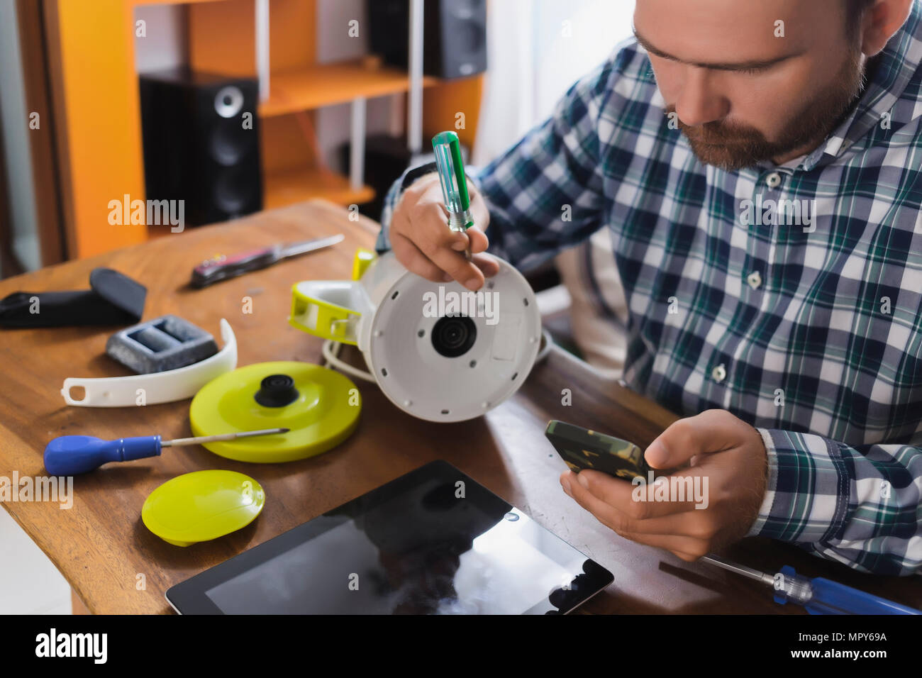 La réparation de l'homme appareil pendant l'utilisation de smart phone at home Banque D'Images