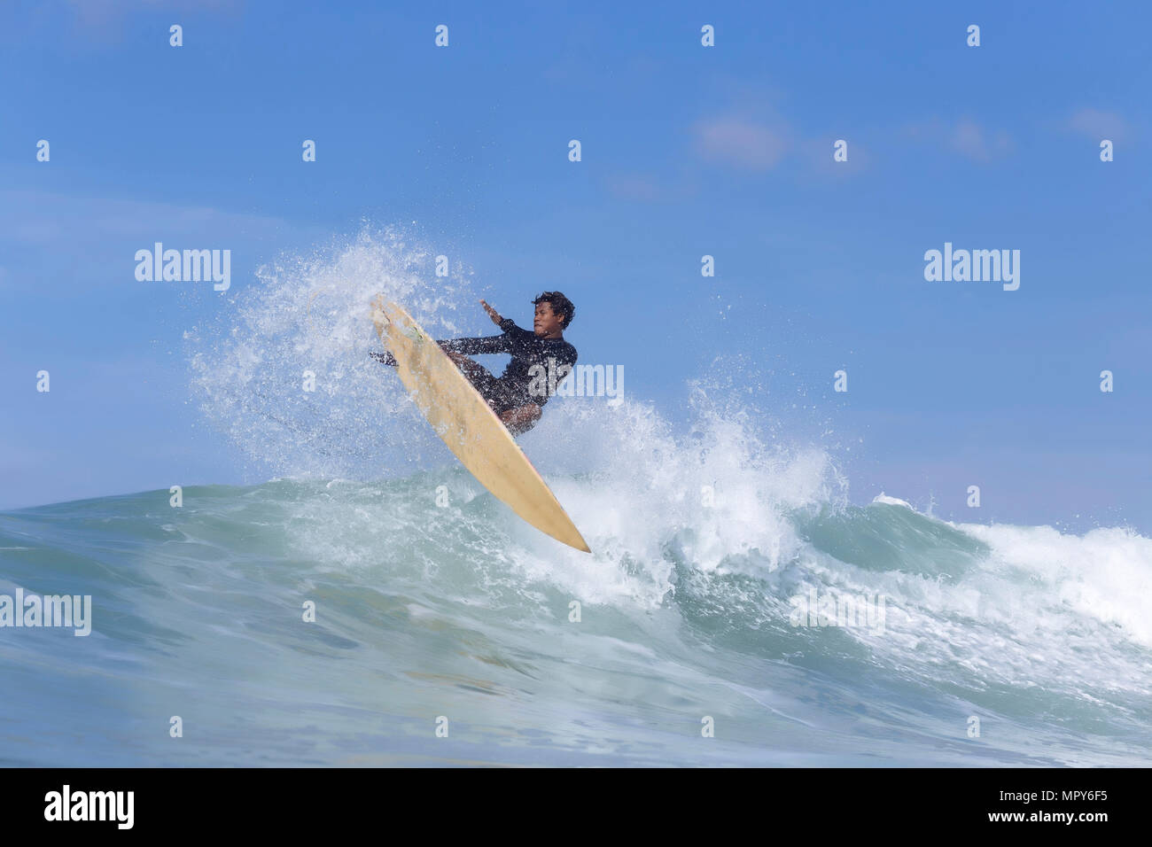 Homme surf sur mer contre ciel bleu Banque D'Images