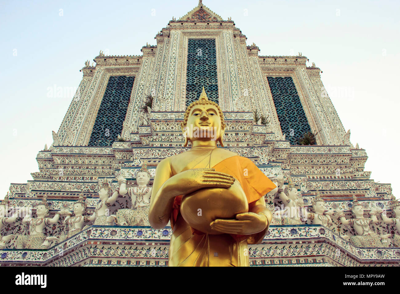 Low angle view of Buddha statue par Wat Arun temple against sky Banque D'Images