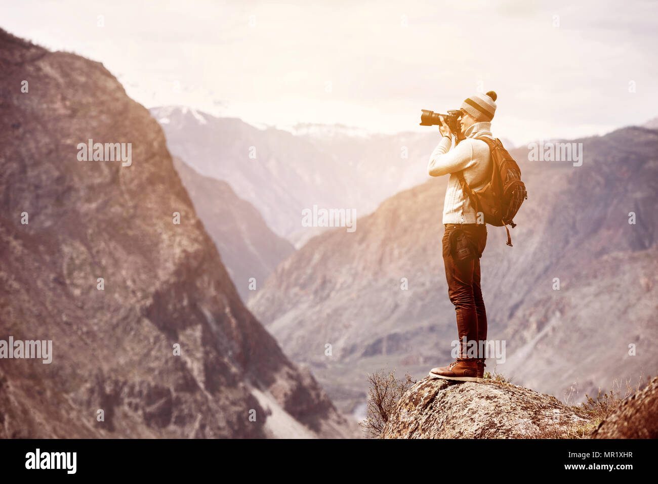 Photographe ou traveller se dresse sur big rock contre les montagnes et taking photo Banque D'Images