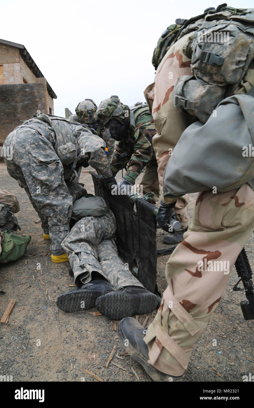 Des soldats américains à partir de la 20ème commande CBRNE, préparer pour le transport des blessés simulés au cours d'un exercice d'entraînement en situation de pertes massives (STX) lane au centre de formation de Yakima, Yakima, Washington, le 28 avril 2017. Les derniers jours de la cours de Dirigeants CBRNE sont constitués de voies STX que d'évaluer ce que les soldats' appris tout au long de la durée du cours. (U.S. Photo de l'armée par le Sgt. Kalie Jones) Banque D'Images