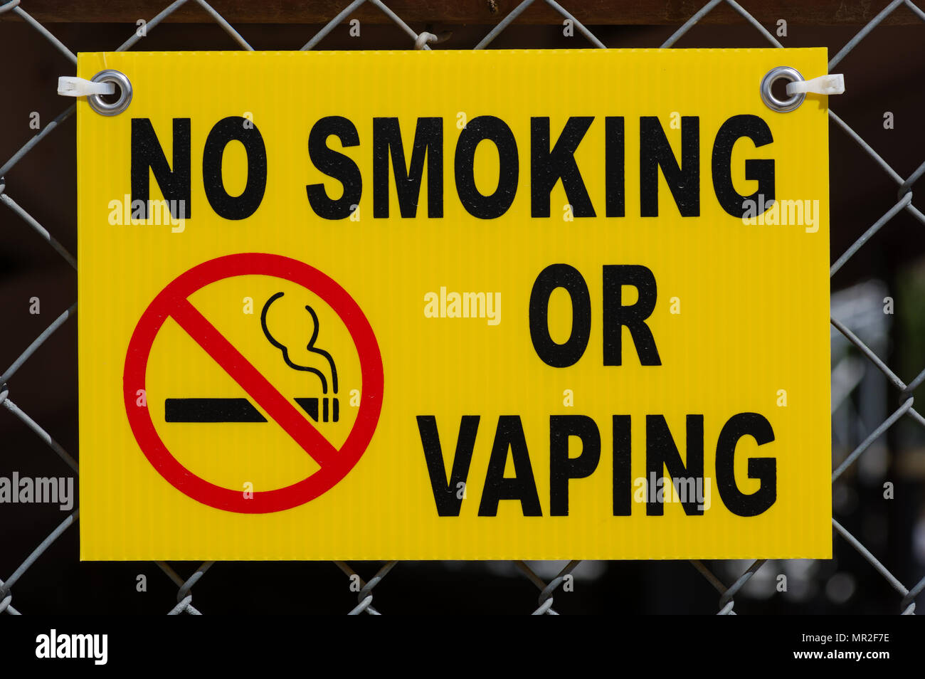 Ne pas fumer ou jaune vaping signer attachée à une CHAÎNE LIEN GRILLAGE Banque D'Images