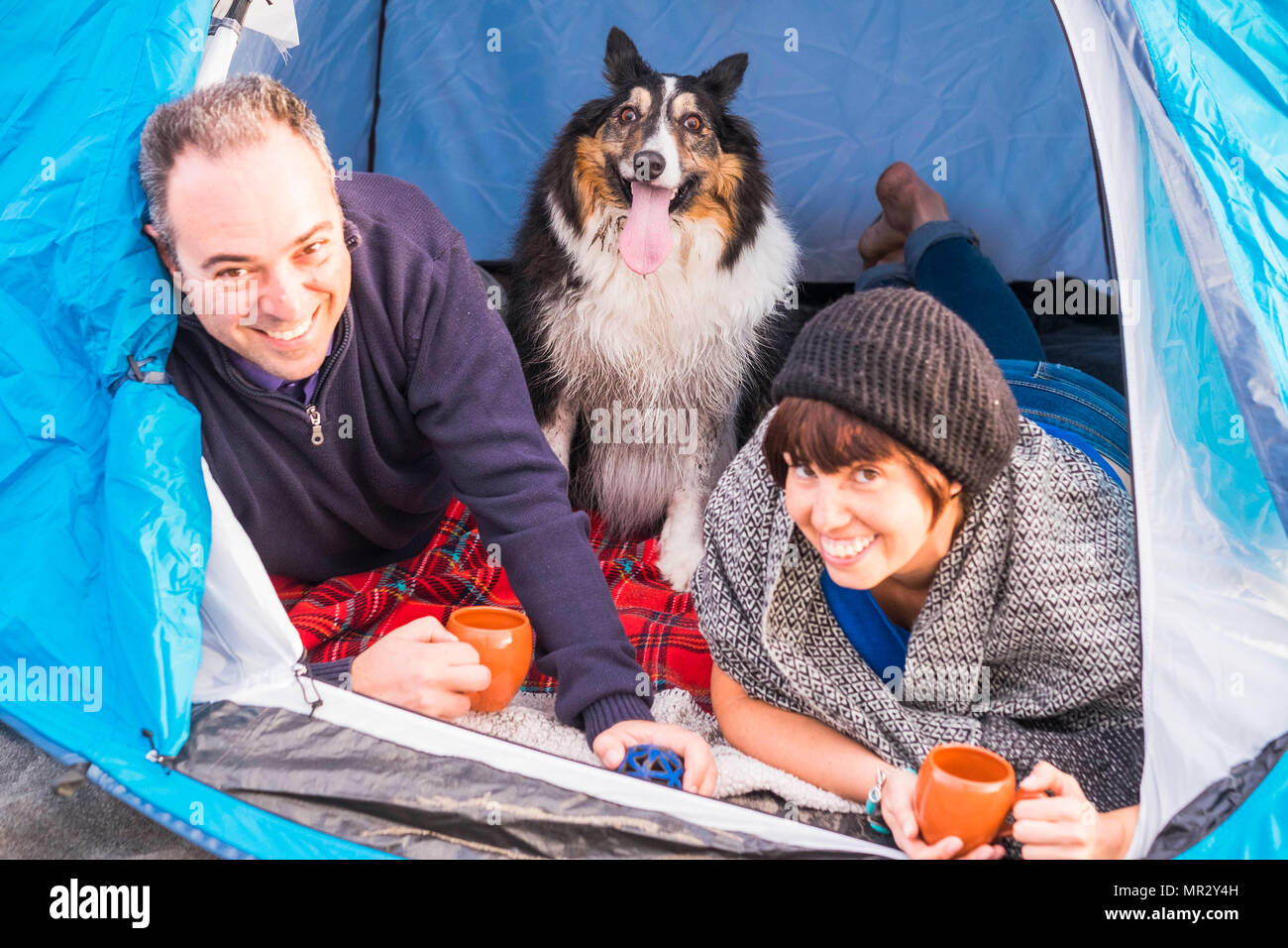 Jeune couple apprécier le camping. Deux personnes et le chien comme une famille. En plein air, sur la plage en face de l'océan Banque D'Images