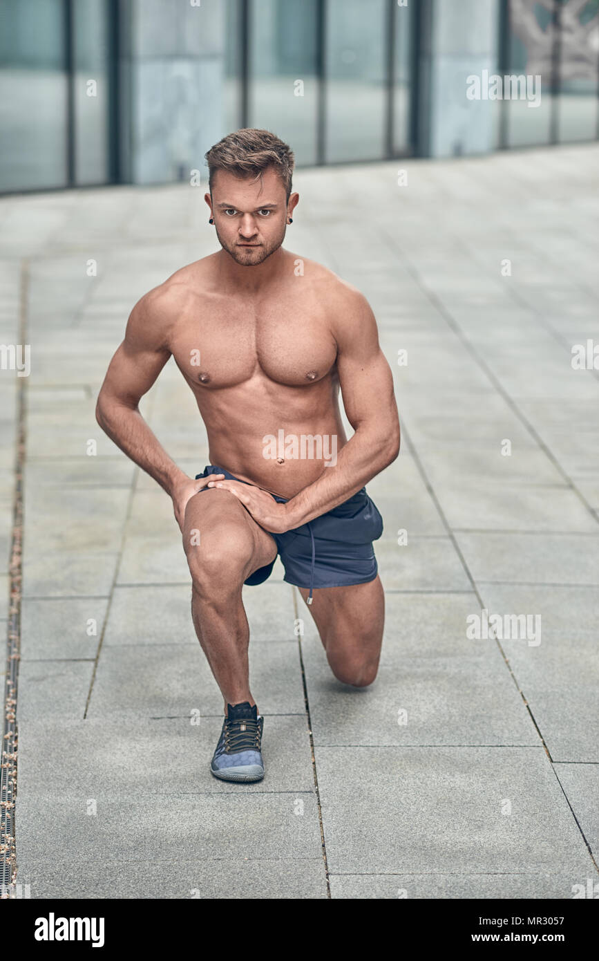 Jeune homme musclé qui s'étend dans un environnement urbain avec copie espace Banque D'Images