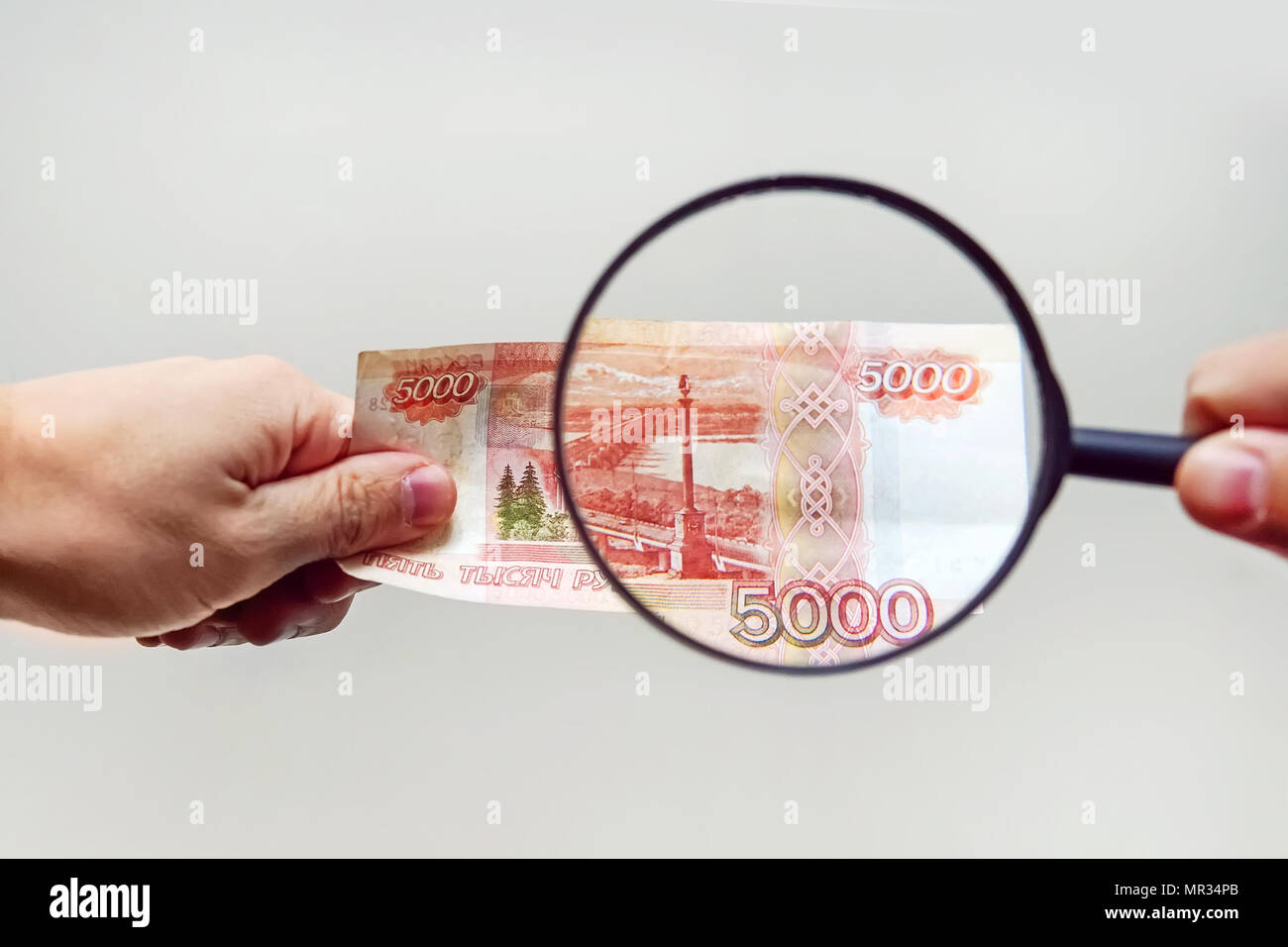 Loupe d'experts vérifie l'argent suspect. Recherchez des filigranes sur du papier de faux billets. loupe, loupe, loupe, magn Banque D'Images