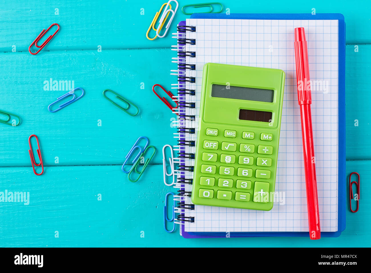Calculatrice et crayon sur le bloc-notes sur le fond bleu Banque D'Images