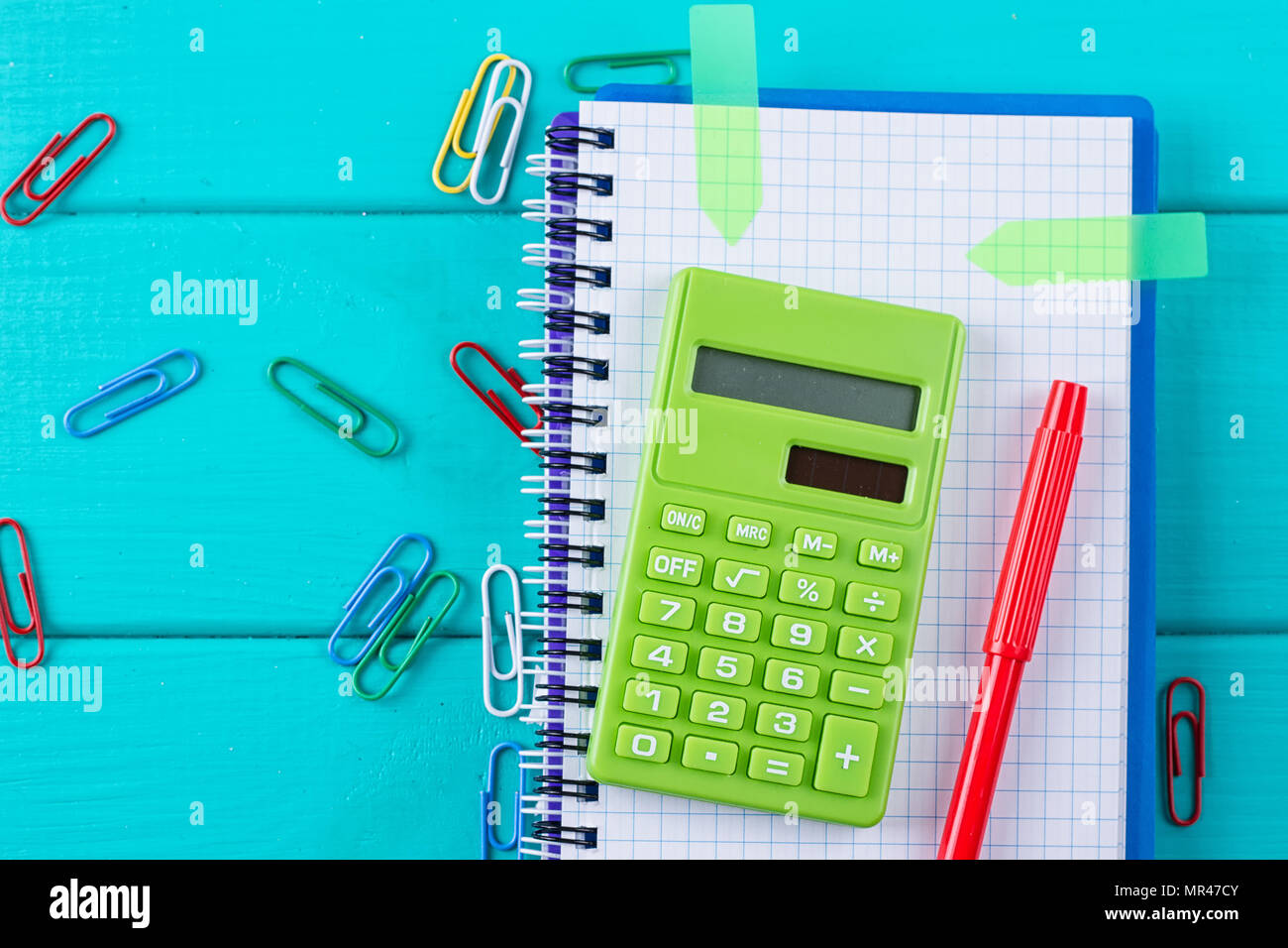 Calculatrice et crayon sur le bloc-notes sur le fond bleu Banque D'Images
