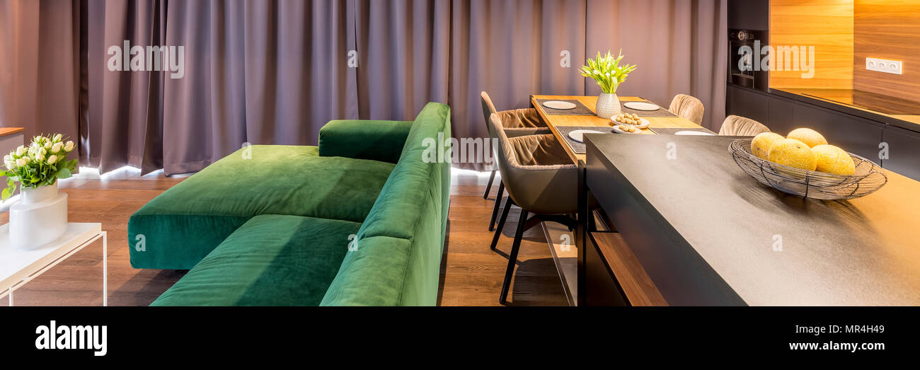 En-tête de l'intérieur salon avec canapé et une cuisine avec une table à manger, chaises, et d'île de cuisine bol d'oranges Banque D'Images