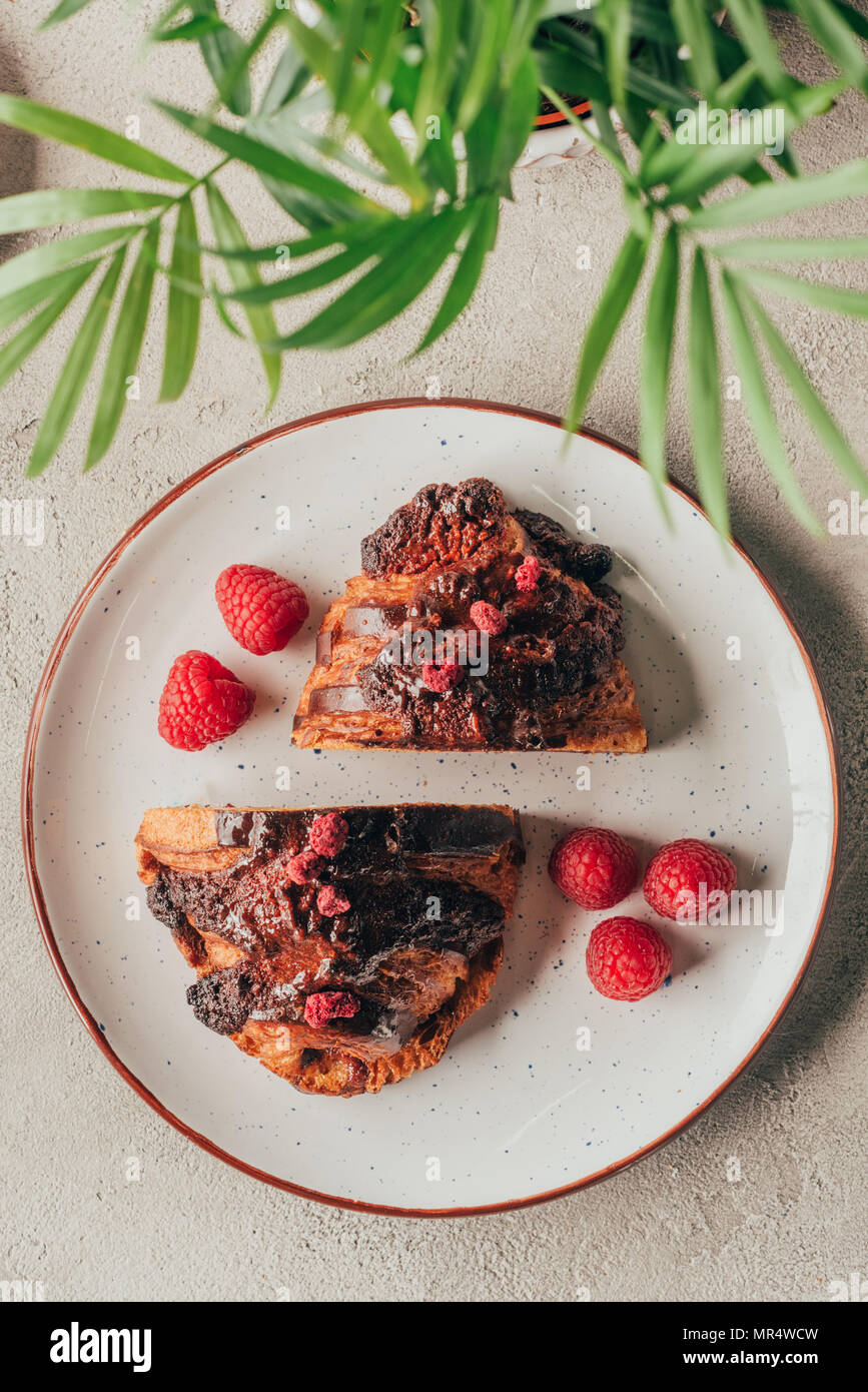 Vue de dessus de pâtisseries sucrées avec des framboises sur la plaque sur la surface d'éclairage Banque D'Images