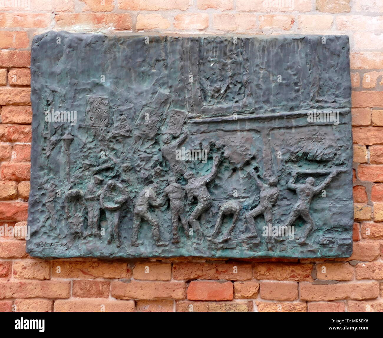 Plaque commémorative à Venise les victimes de l'Holocauste, à Venise, Campo del Ghetto Nuovo, près d'une sculpture commémorative par Arbit Blatas. Banque D'Images