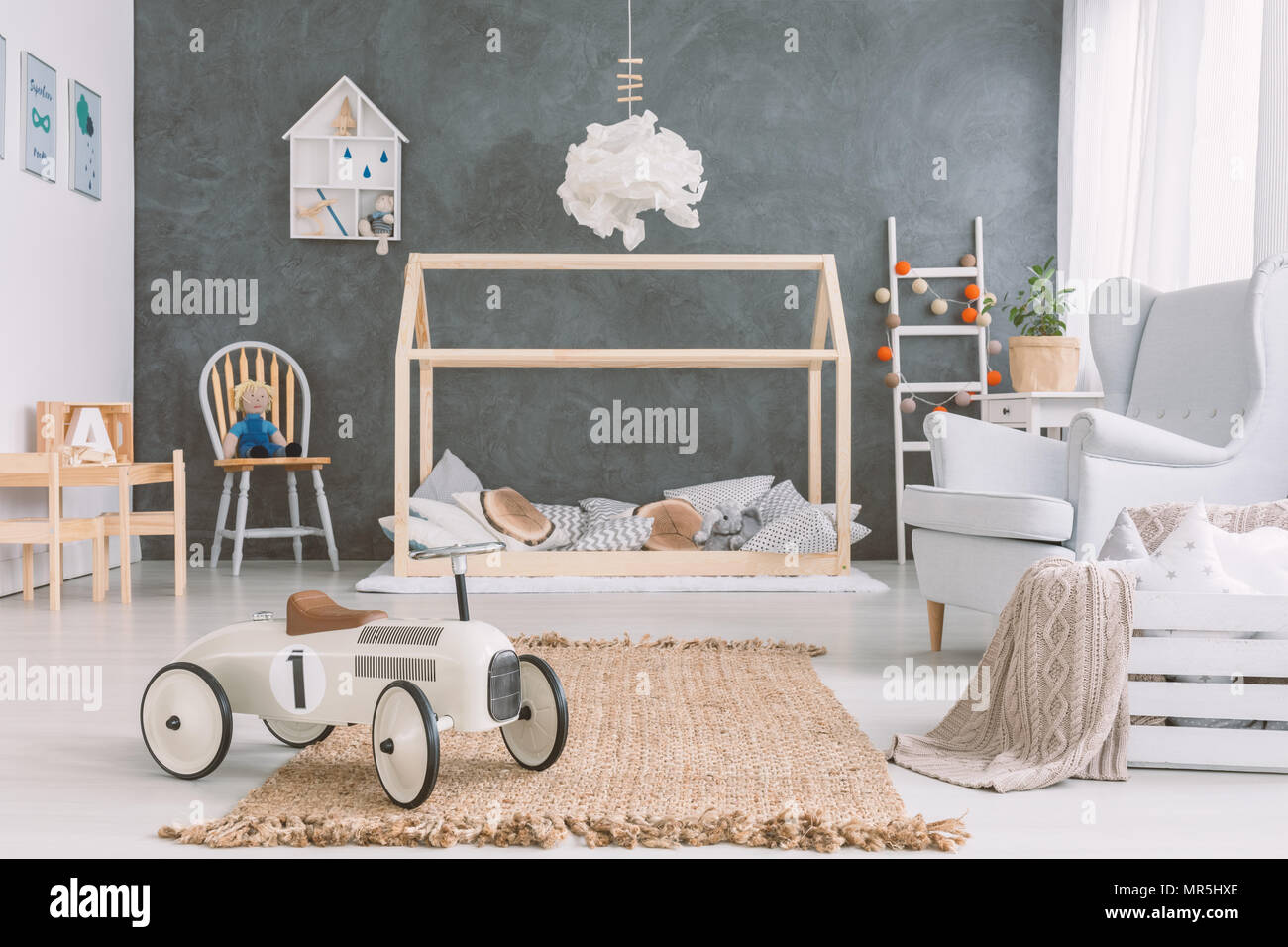 Chambre de bébé dans un style scandinave avec fauteuil et lit en bois Banque D'Images