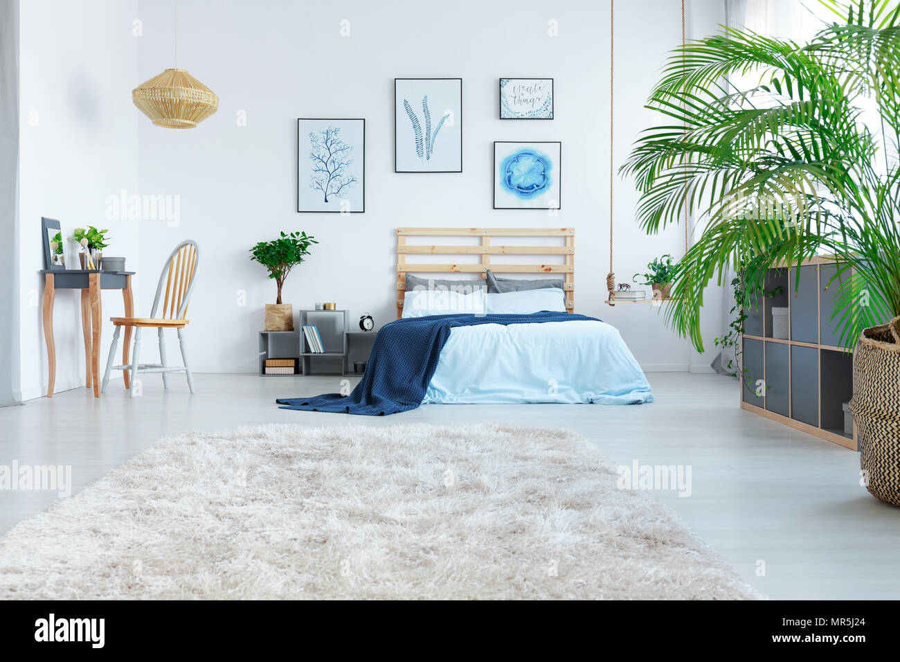 Chambre élégante avec lit, coiffeuse en bois et des plantes Photo Stock -  Alamy