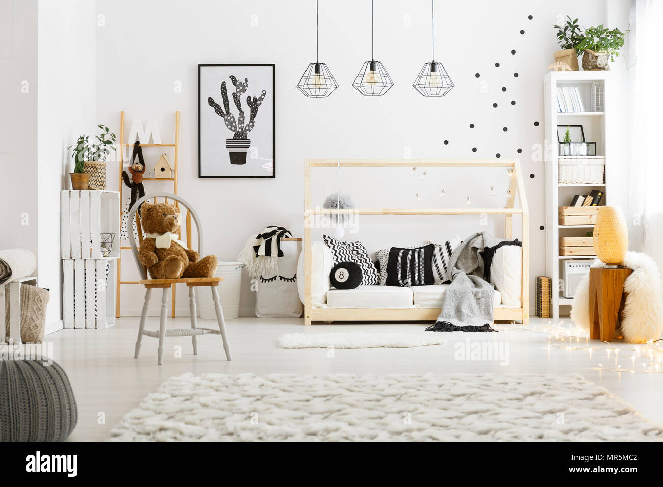 Chambre enfant blanc avec tapis, pouf, fauteuil, lit et bibliothèque Banque D'Images
