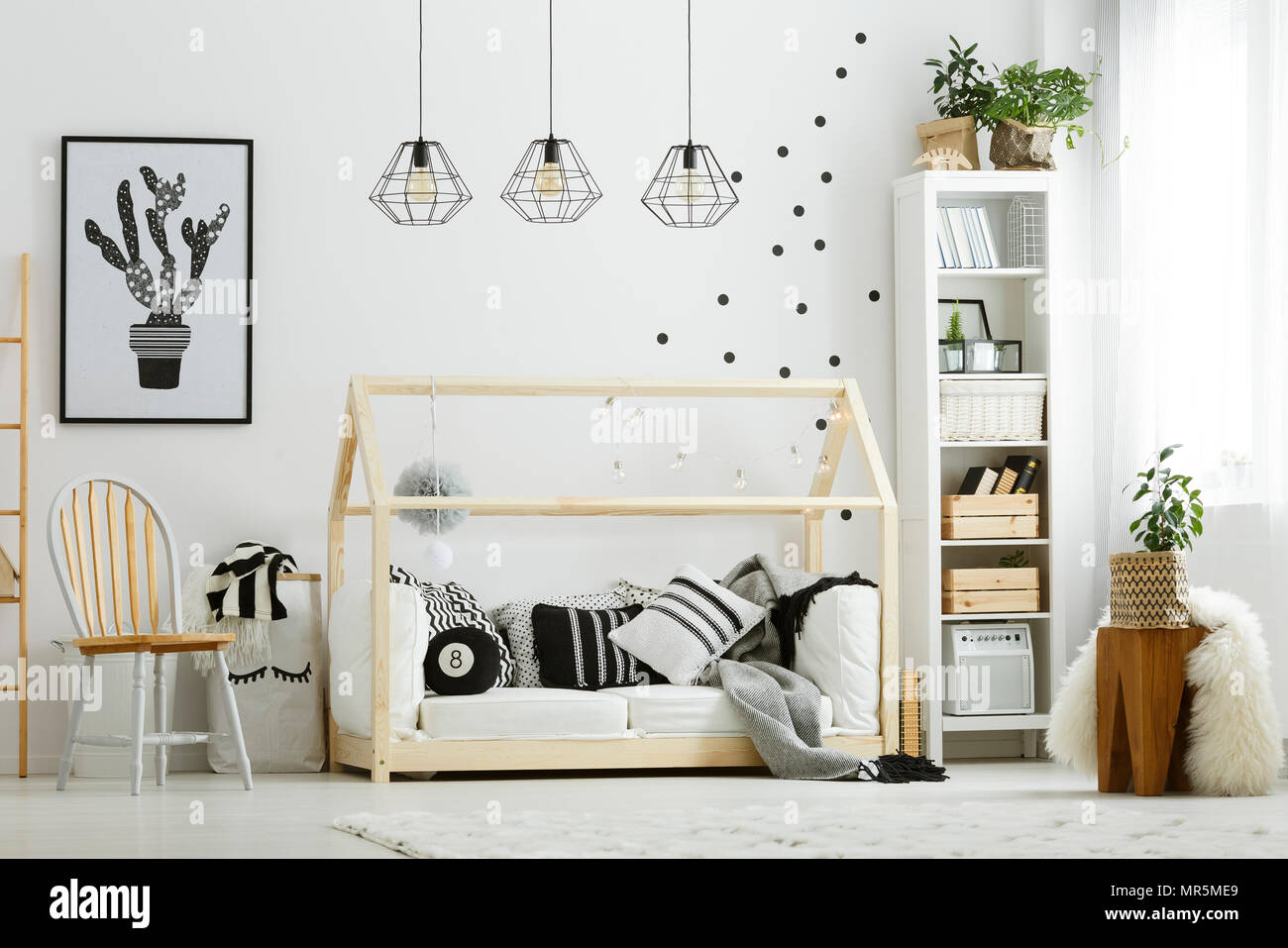 Chambre à coucher bébé dans un style scandinave avec lit et chaise en bois Banque D'Images