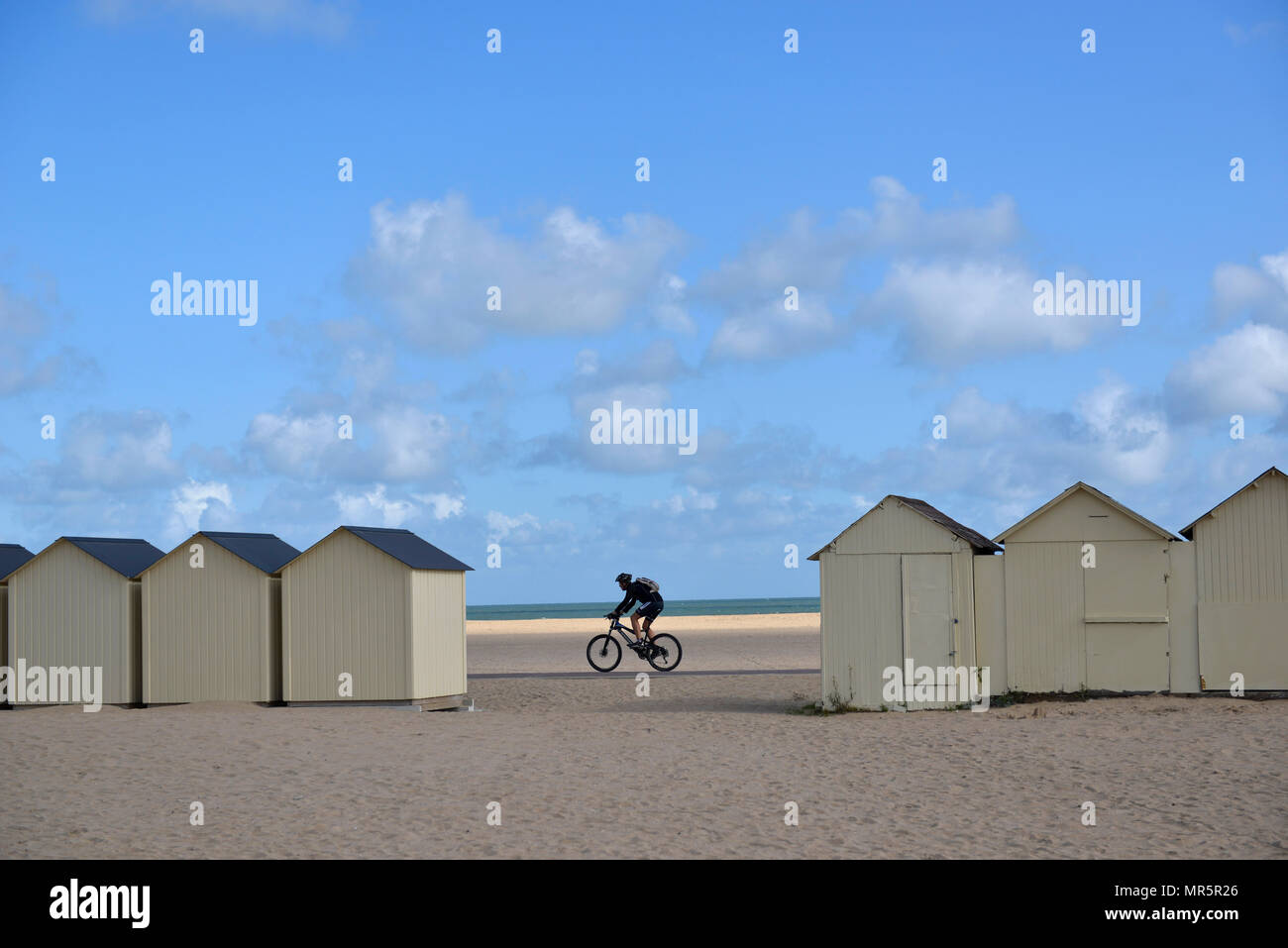 Ouistreham (Normandie, nord-ouest de la France) : l'homme le vélo sur la plage et maisons de plage Banque D'Images
