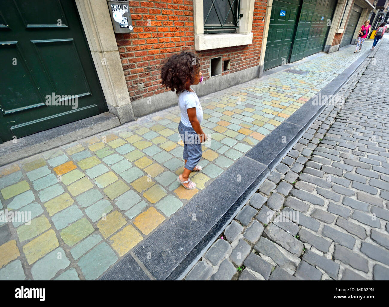 Jeune enfant seul avec un mannequin dans une rue de Bruxelles, Belgique. Banque D'Images