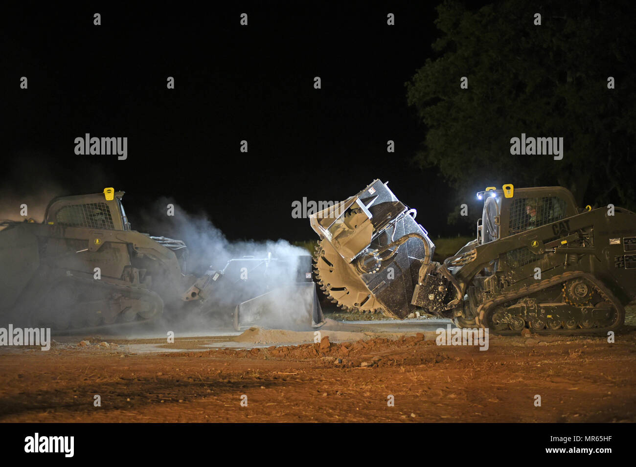 170517-N-DH124-240 FORT HUNTER LIGGETT, Californie (17 mai 2017) attribué à Seabees Mobile Naval Construction Battalion (NMCB) 4 mini-chargeurs fonctionnent avec une scie béton pièce jointe pour réparer les dégâts d'une simulation d'airstrike à Fort Hunter Liggett, en Californie, au cours de l'exercice d'entraînement sur le terrain. L'exercice donne l'occasion de pratiquer Seabees et appliquer des compétences de guerre combat seabee, fournir l'appui de la sécurité de la nation hôte et rester prêt de la mission dans un environnement simulé destiné à reproduire dans le pays de la paix. (U.S. Photo par marine Spécialiste de la communication de masse 1re classe Rosalie Banque D'Images