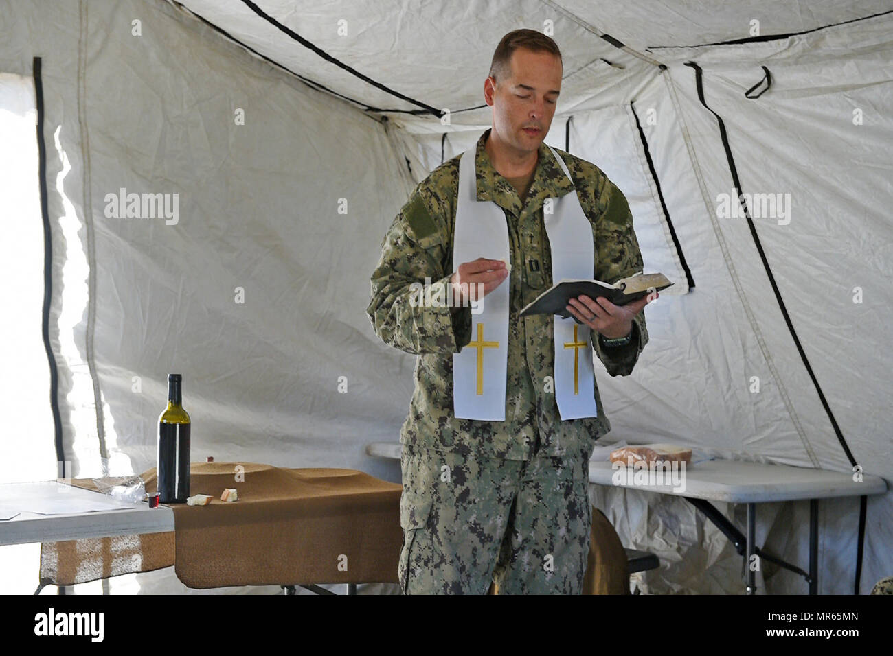 170514-N-DH124-038 FORT HUNTER LIGGETT, Californie (14 mai 2017) Le lieutenant Brady Rentz, un aumônier de la Marine affecté au bataillon de construction Mobile (NMCB), 4 lit un verset de la Bible pendant les services religieux à Fort Hunter Liggett, en Californie, au cours de l'exercice d'entraînement sur le terrain. NMCB-4 procède à leur classement final de l'exercice de formation sur le terrain, le test de l'élément de commandement, de contrôle et les fonctions de communication grâce à une variété de scénarios réels rencontrés pendant les déploiements. (U.S. Photo par marine Spécialiste de la communication de masse 1re classe Rosalie Chang/libérés) Banque D'Images