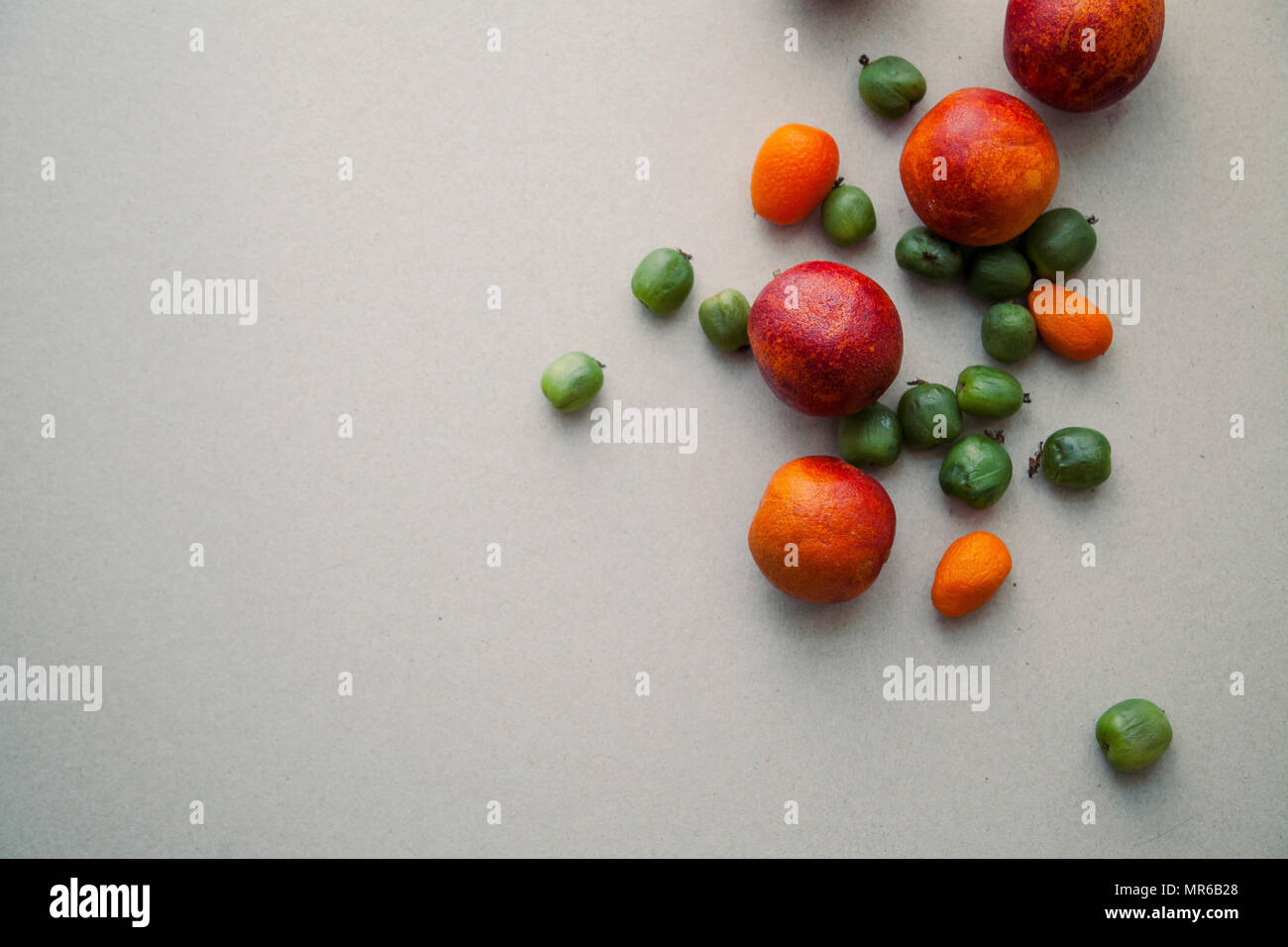 Varitety de fruits d'été frais sur fond neutre avec mini kiwis et oranges rouge Banque D'Images